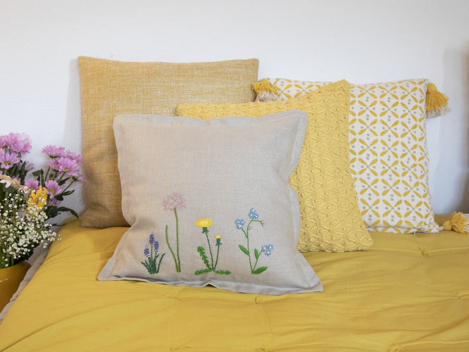 Blumenstickereien auf Kissen auf einem Bett | © Birgid Allig